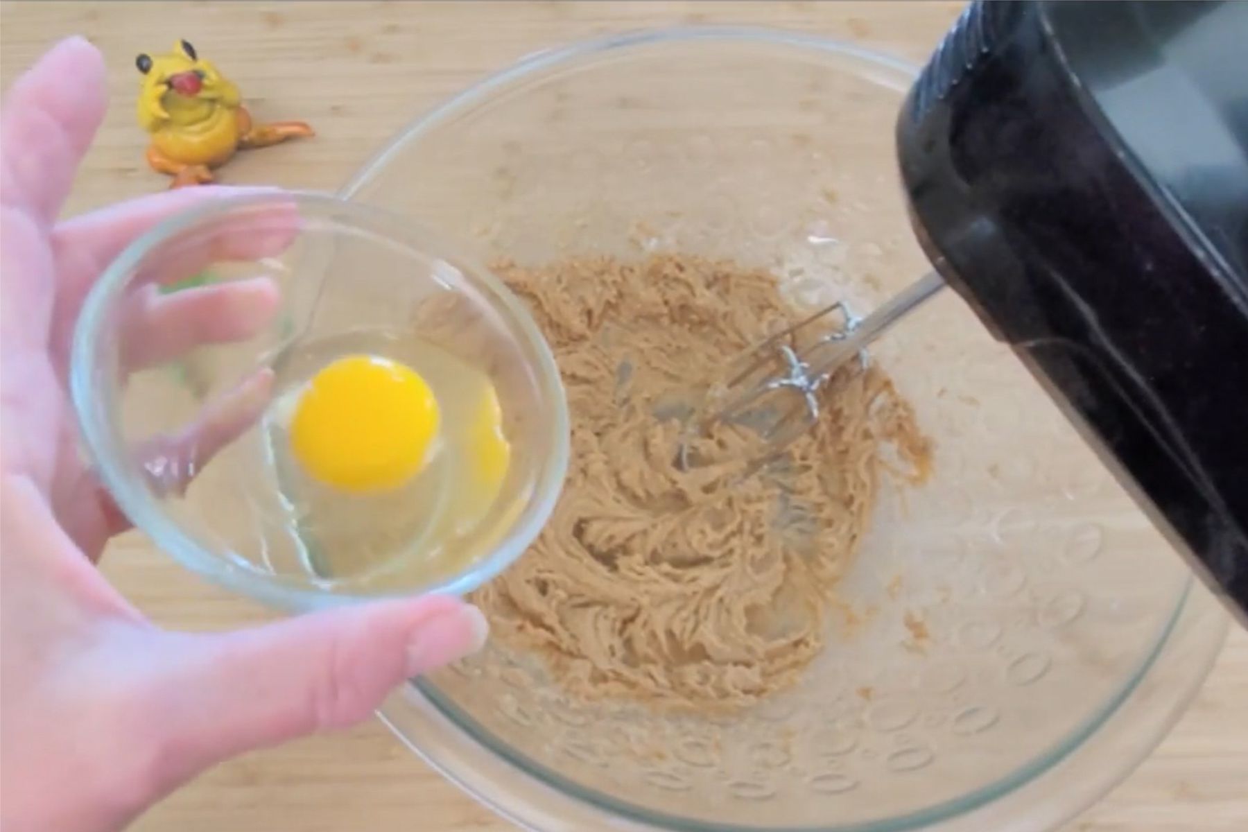 adding egg to mixing bowl