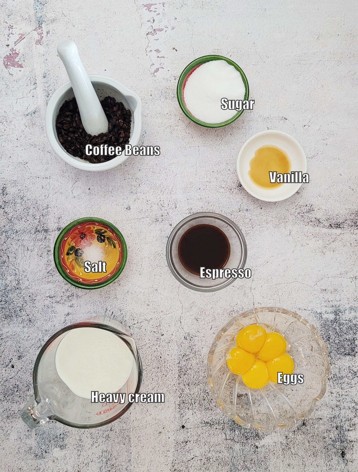 ingredients needed to make the coffee crème brulee recipe including cream, egg yolks, vanilla, granulated sugar, coffee beans, brewed espresso and salt