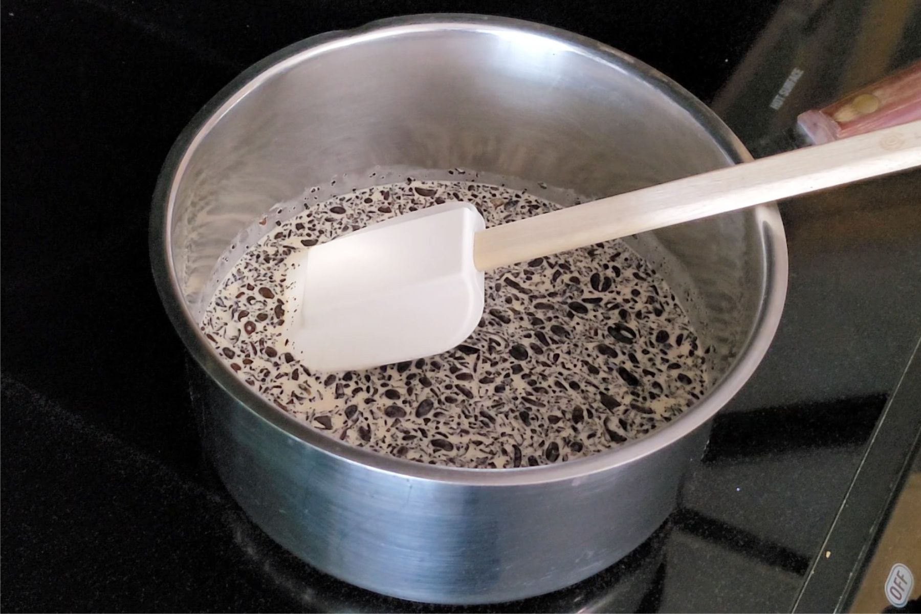 cream, espresso and coffee beans in a saucepan over a stovetop
