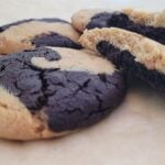 close up view of peanut butter chocolate swirl cookies with one cookie broken open to show the inside