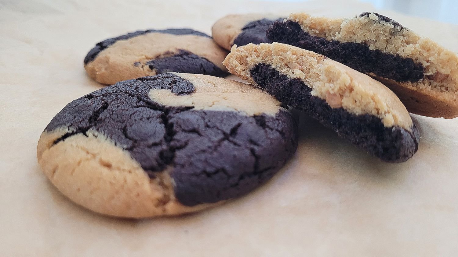 close up view of peanut butter chocolate swirl cookies with one cookie broken open to show the inside
