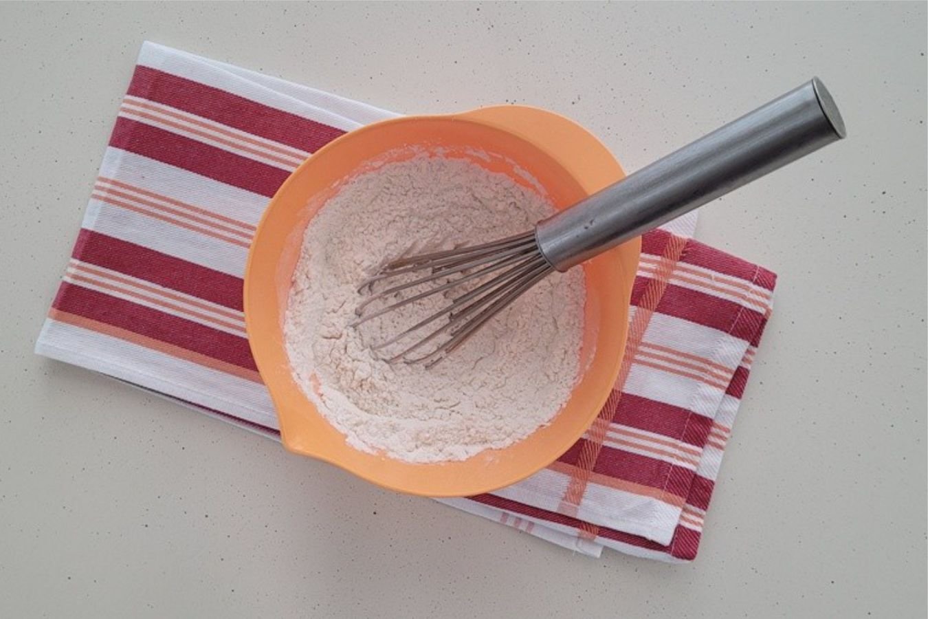 overhead view of dry ingredients whisked together in a bowl to make dough