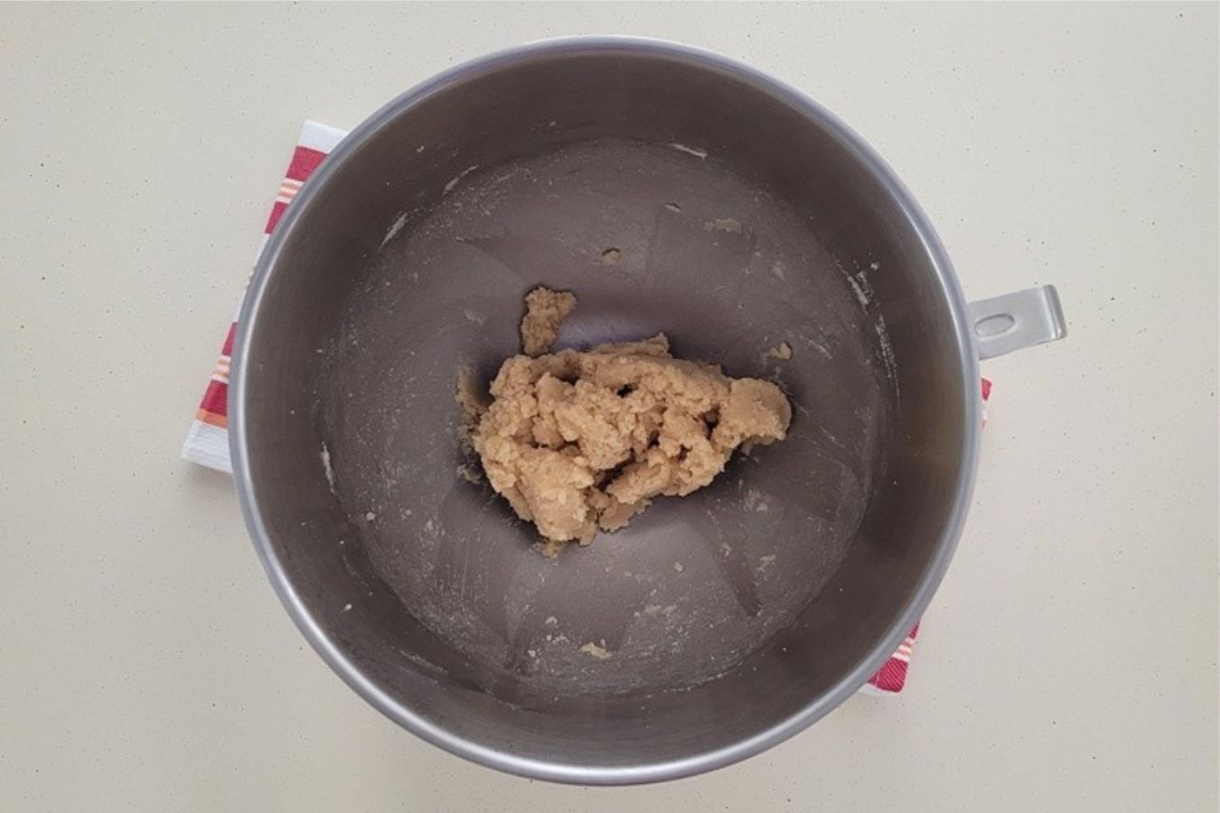 overhead view of a mixing bowl with brown sugar, granulated sugar and butter creamed together for peanut butter dough