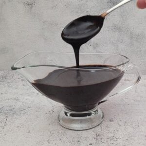 spoon drizzling chocolate sauce into a serving dish