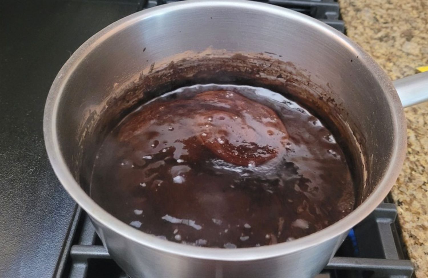 chocolate sauce ingredients boiling in a pan over stove top