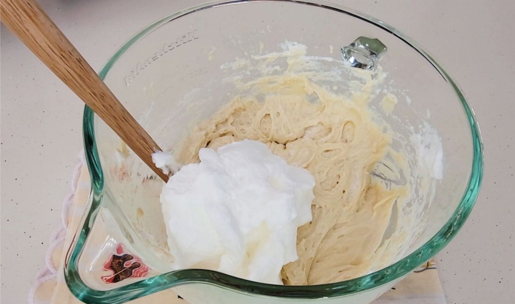 whipped egg whites added to mixing bowl to be folded into cake batter