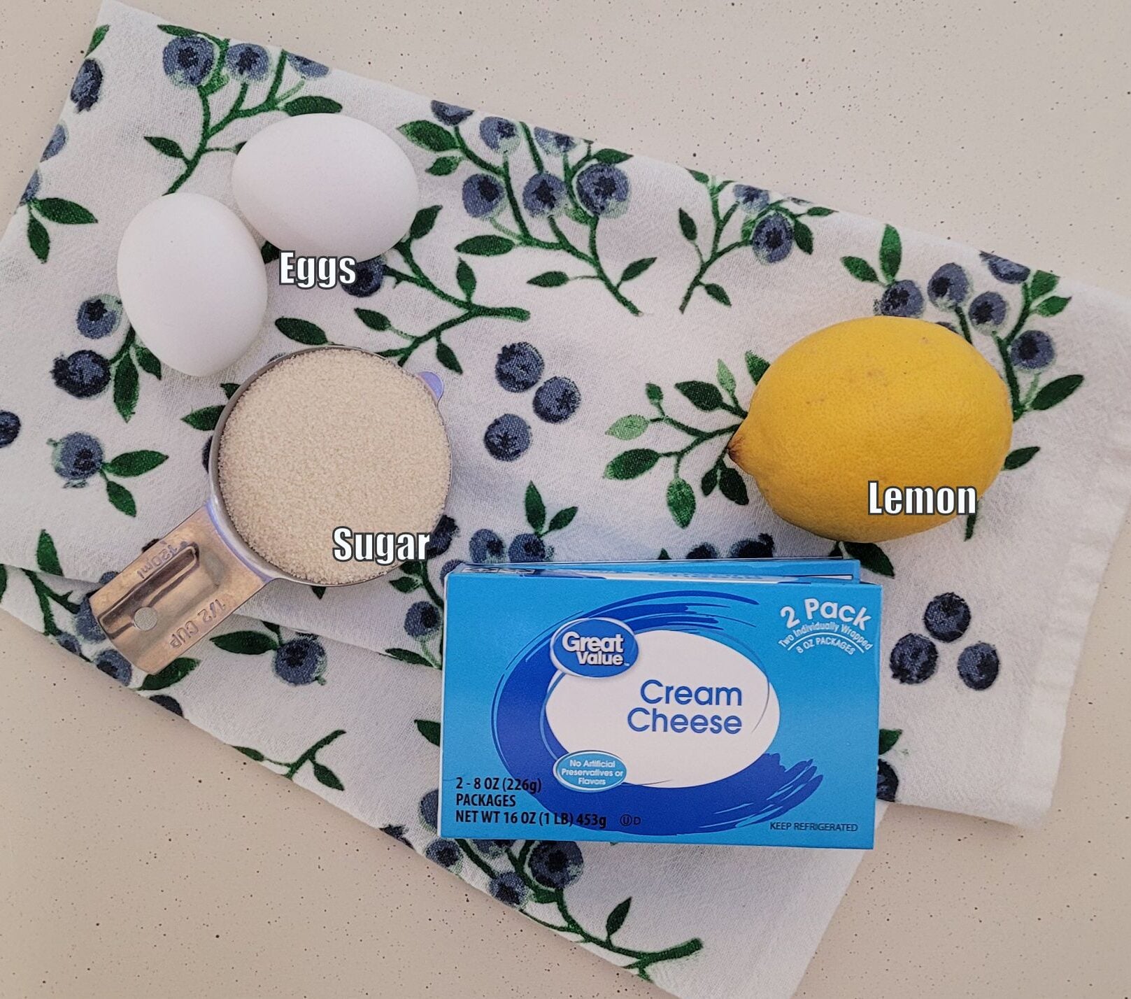 ingredients needed to make cheesecake bars filling including lemon, cream cheese, sugar and eggs