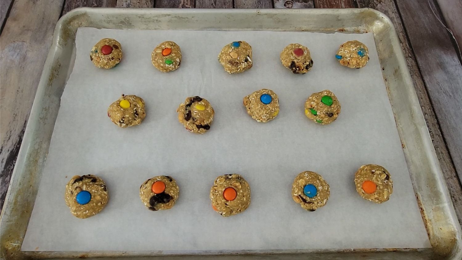 balls of oatmeal GORP cookie dough scooped onto a baking sheet pan lined with parchment paper