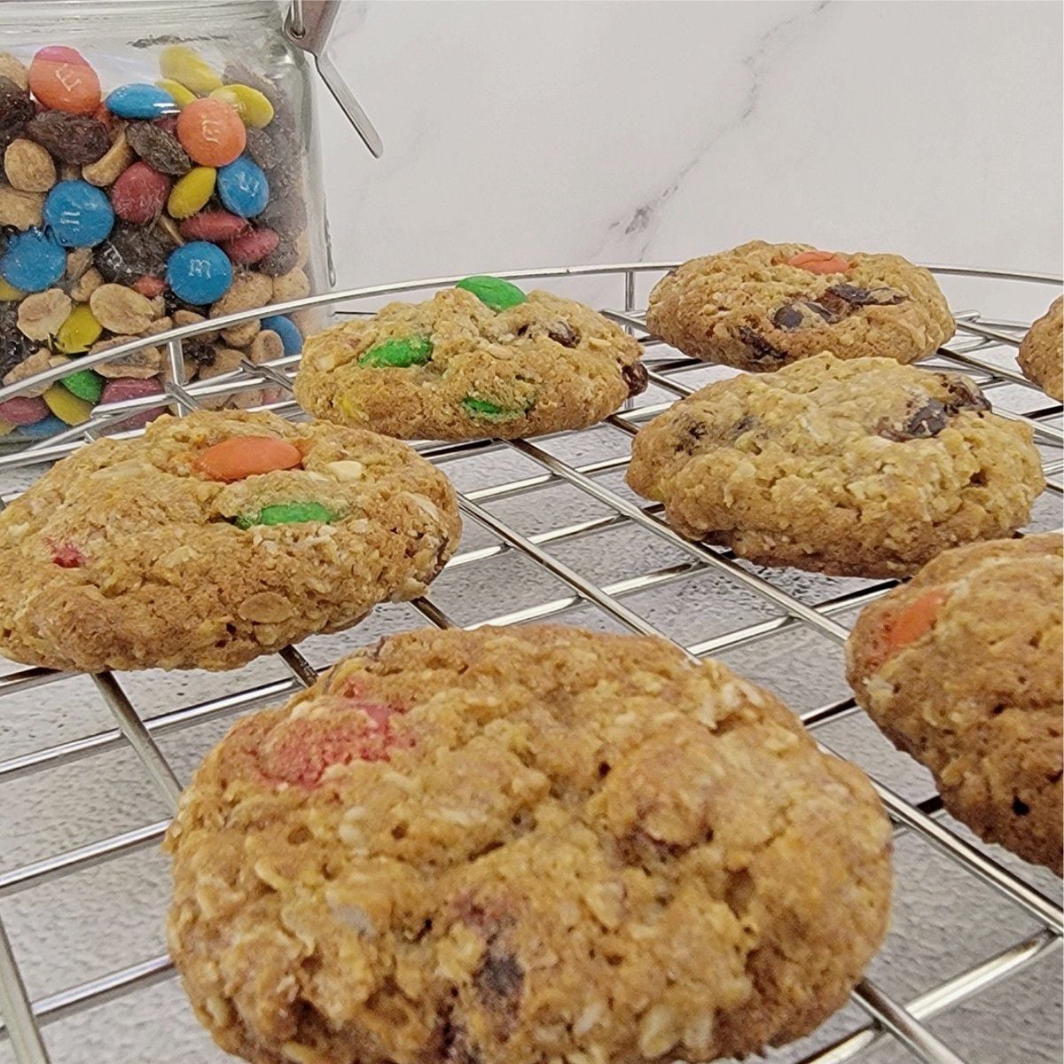 GORP cookies on a cooling rack with a jar of GORP in the background
